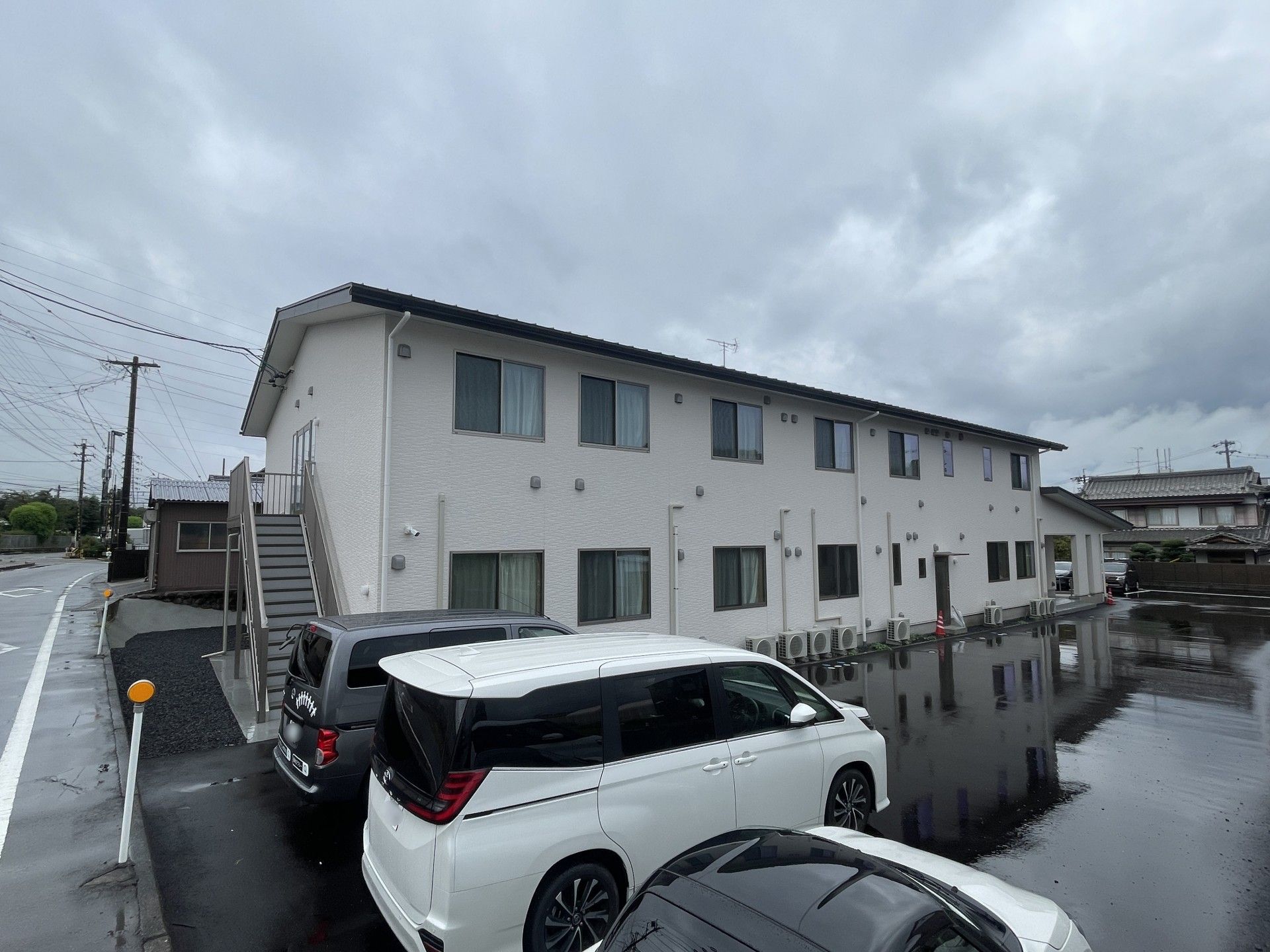 白い建物と駐車場