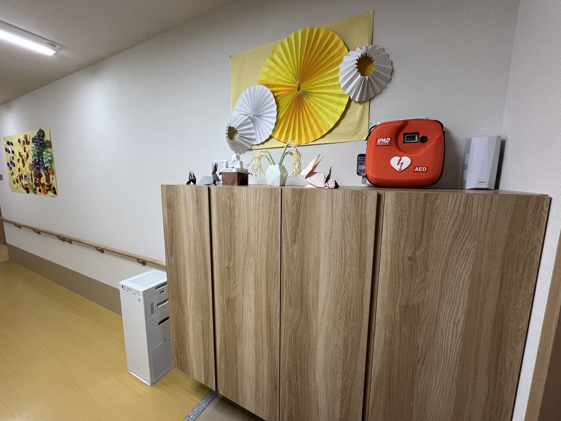 飾り棚とAEDのある廊下