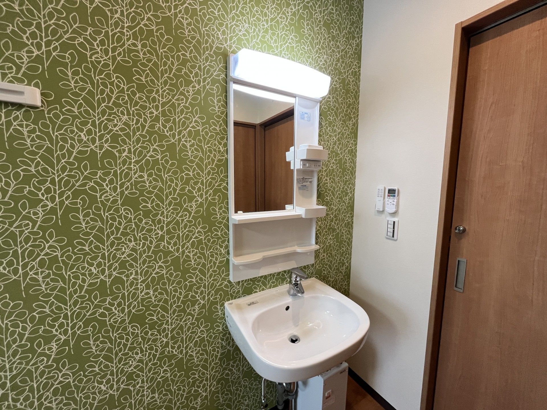 緑の壁紙と洗面台