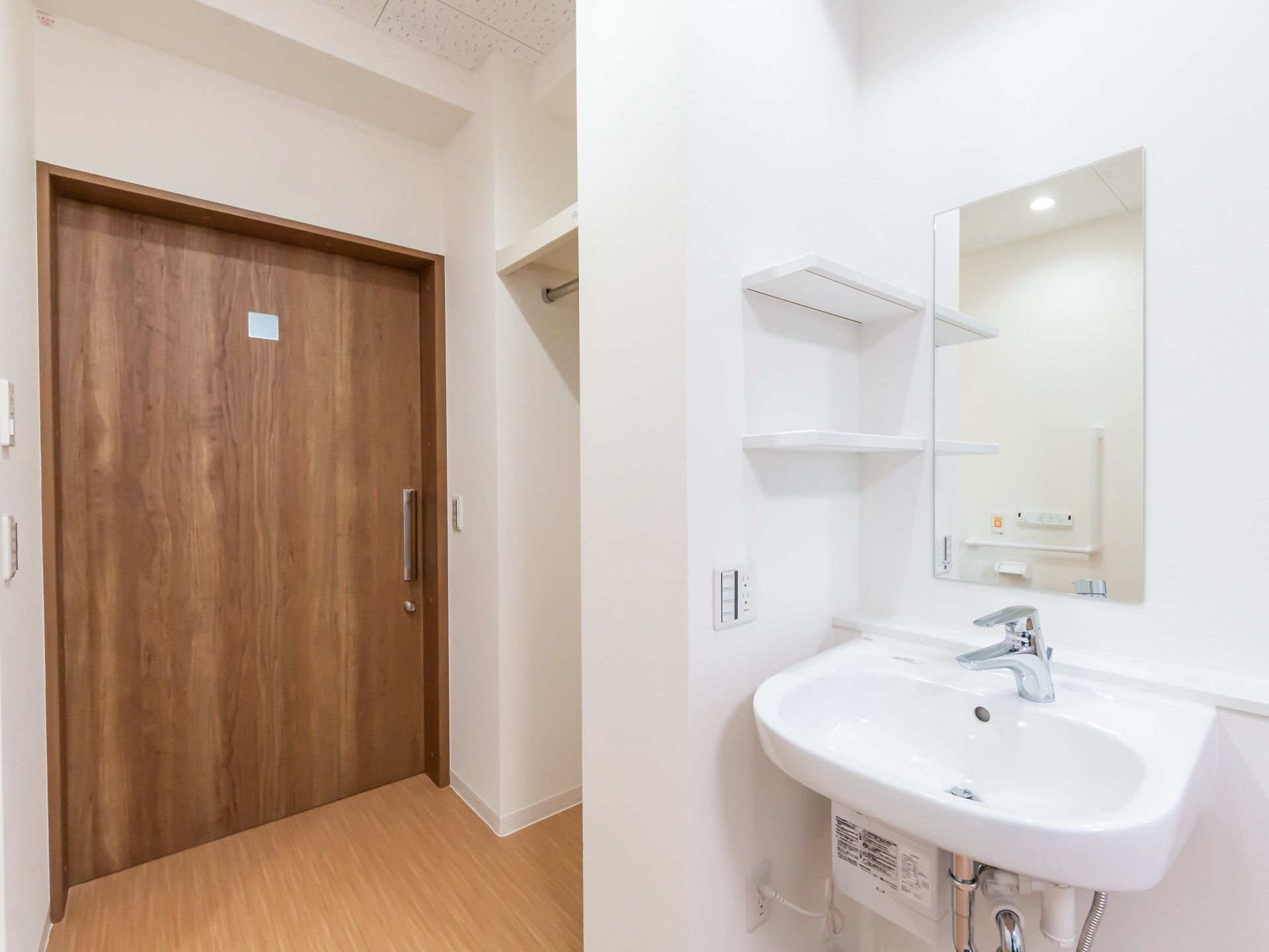 清潔な洗面台と木製の扉