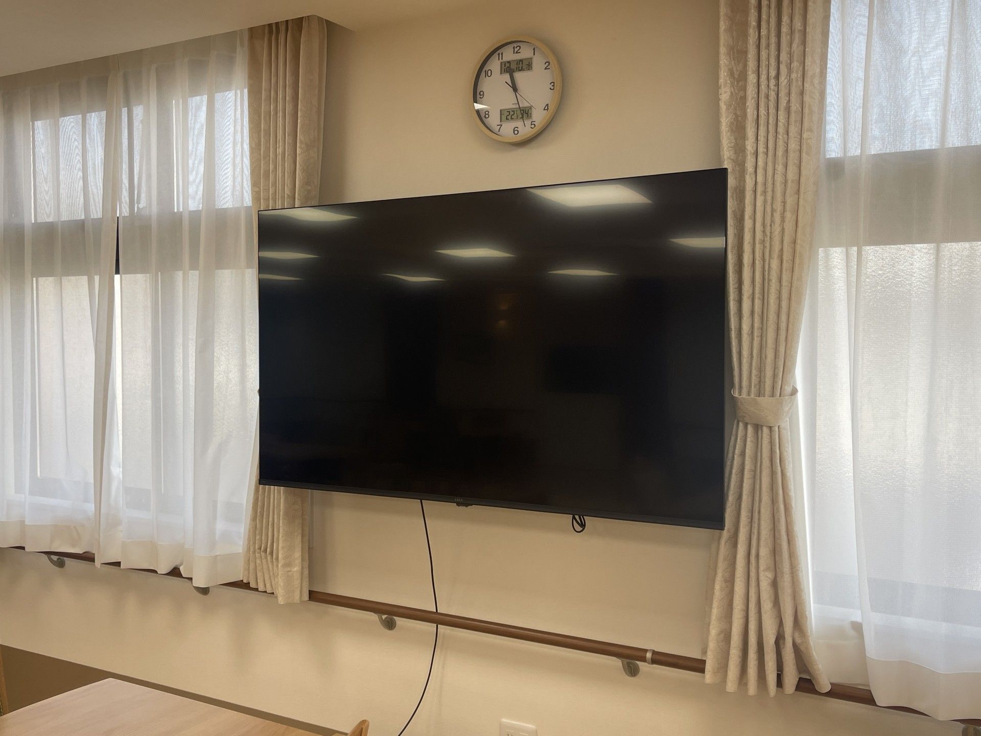 大きなテレビと時計の壁