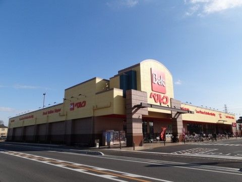 生活用品を買うことできるスーパーが施設の近くにある。赤い看板が目印になっている。建物前には駐車場や駐輪場が設けられている。
