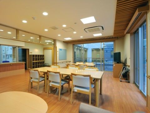 窓から中庭や反対側の部屋が見えている。窓の上部と天井には木材を用いており、木のぬくもりが感じられるスペースである。