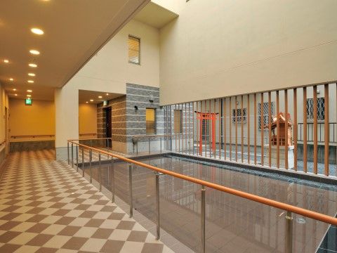 敷地内に建つ祠や鳥居が見えて、文化的な雰囲気が漂う廊下
