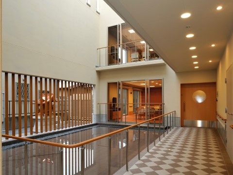 共有スペースの窓の外は、施設の吹き抜け部分である。また廊下からは、水辺や柵を隔てて、屋外が見える仕組みである。