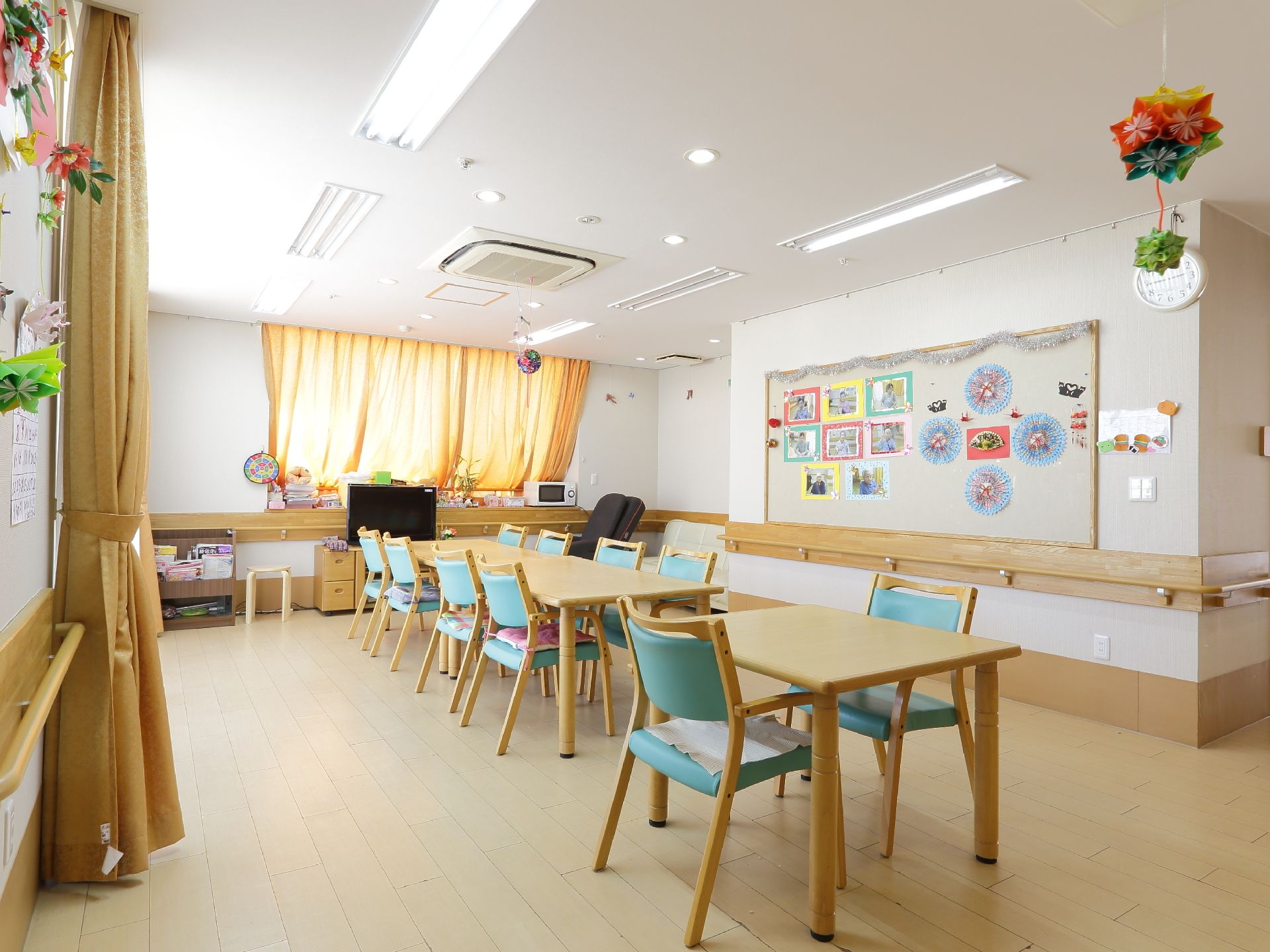 入居者が様々なレクリエーションの際にも利用する部屋である。安全を考えて、広い空間を確保して、壁には手すりをつけている。