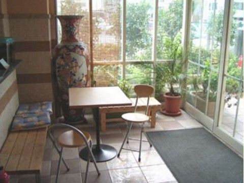 中央にはテーブルと椅子が用意されている。背もたれのないベンチが壁際に置かれている。背丈ほどの壷が飾られている。