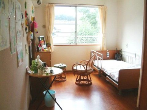 床面はフローリングで段差がない。ワンルームタイプで、腰高窓がある。介護ベッド、エアコンが設置されている。