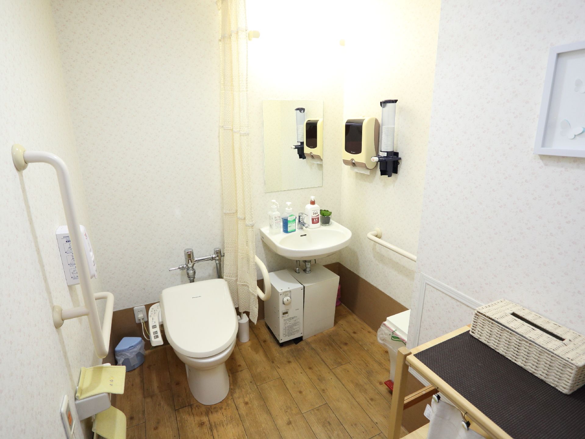 左手にはウオッシュレットトイレがあり壁には手すりとナースコールもついている。右手には流しがついている。