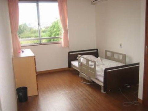 室内の窓から緑鮮やかな自然を臨む、明るく開放的な部屋