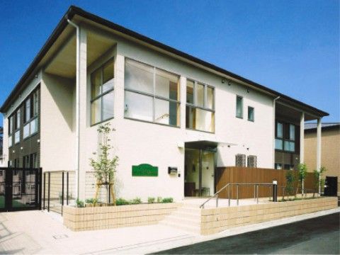 窓が大きめで日当たりの良い２階建ての施設で、周りに高い建物がない。アットホームな外観で親しみが感じられる。