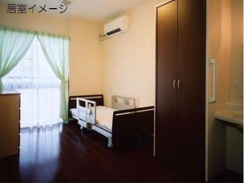 ダークブラウンのフローリングの床である。部屋に備え付けられた洗面台は、足元に充分なスペースが確保されている。