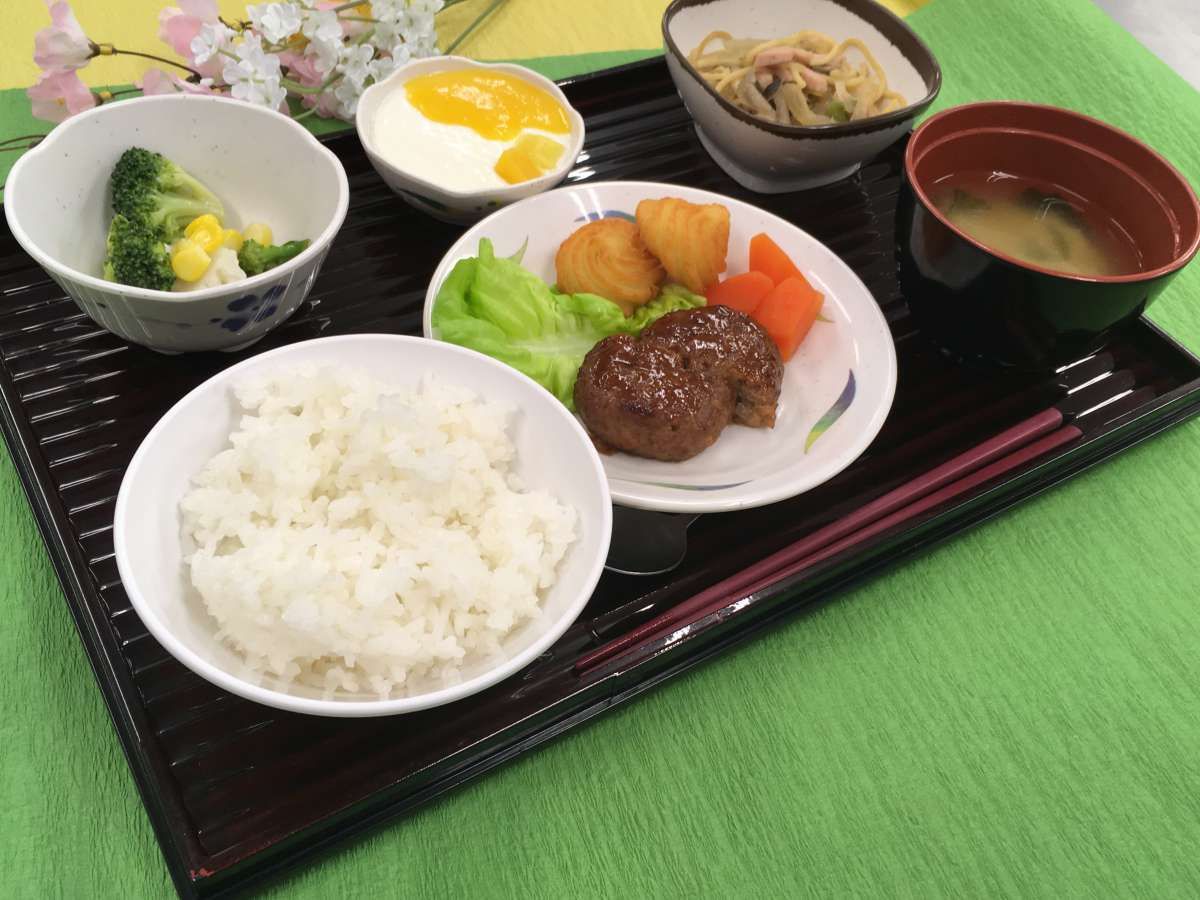 人参を添えたハンバーグがメインのご飯と味噌汁が付いたセット