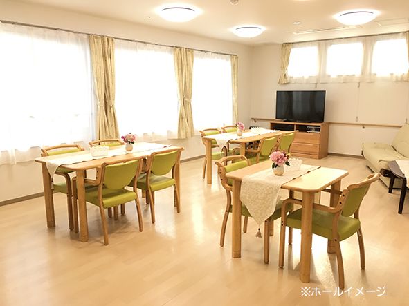 食堂は明るくゆったりとした開放的な空間となっている。４人掛けのテーブルが２つ並べて配置されていて、ピンクの椅子が８脚セットされている。