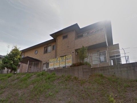 下から見上げた位置に佇む２階建ての施設である。建物横に洗濯干場を設けている。日あたり良好なので、洗濯物も気持ちよく乾く。