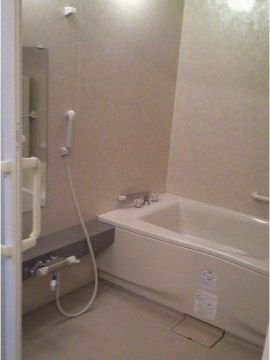 ご家庭と同じような浴室で、気を遣わずにゆったりとご利用いただける。アイボリー色の浴室で落ちつた色合いである。