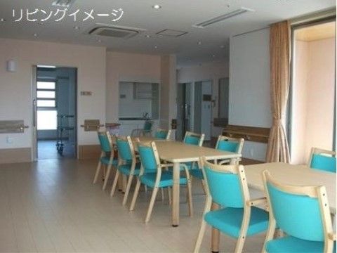 リビングには椅子やテーブルがあり、日当たりがよい。壁沿いには手すりが付いているので、移動の際に転倒の心配がなく安心である。