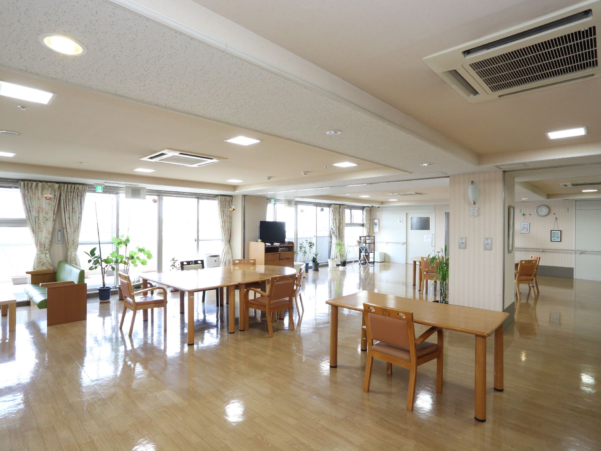 空調のついたフローリングの部屋には木製のテーブルと椅子が数台置かれている。窓際には観葉植物も置いてある。