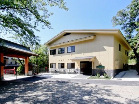 お寺の境内に建つ、玄関先に大きな庇がついた2階建ての建物