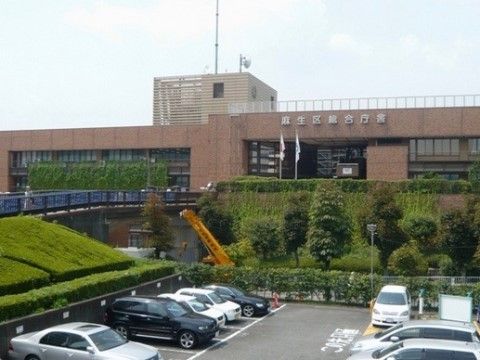 生け垣や高い木に囲まれた、区役所の総合庁舎がある。手前に広い駐車場が整備されている。各種手続きにも便利な立地である。