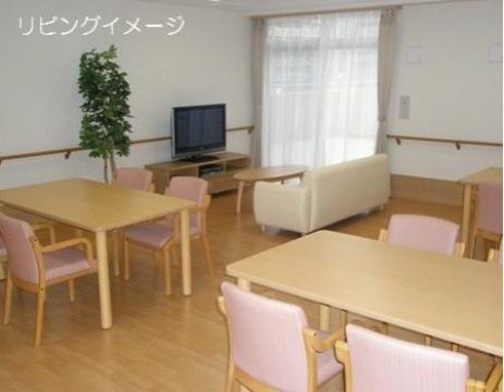 ピンク色の椅子と明るい色のダイニングテーブルが設置された共有スペースである。テレビもあり、ゆっくりした時間が過ごせる。