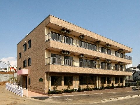 ベランダがあり、大きな窓がついている3階建ての建物