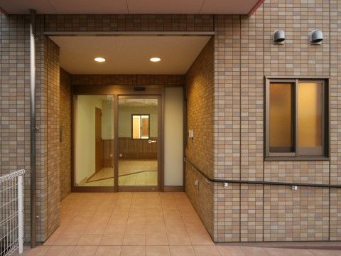 ブラウン系のレンガ調の玄関である。入口は自動ドアで、周辺は段差がないので、車椅子をご利用の方も通り抜けやすい。