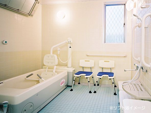 洗濯機を浴室内に設置している。介護度の高い入居者様も入浴ができるように、リフト付きの介護用入浴機器を備え付けている。