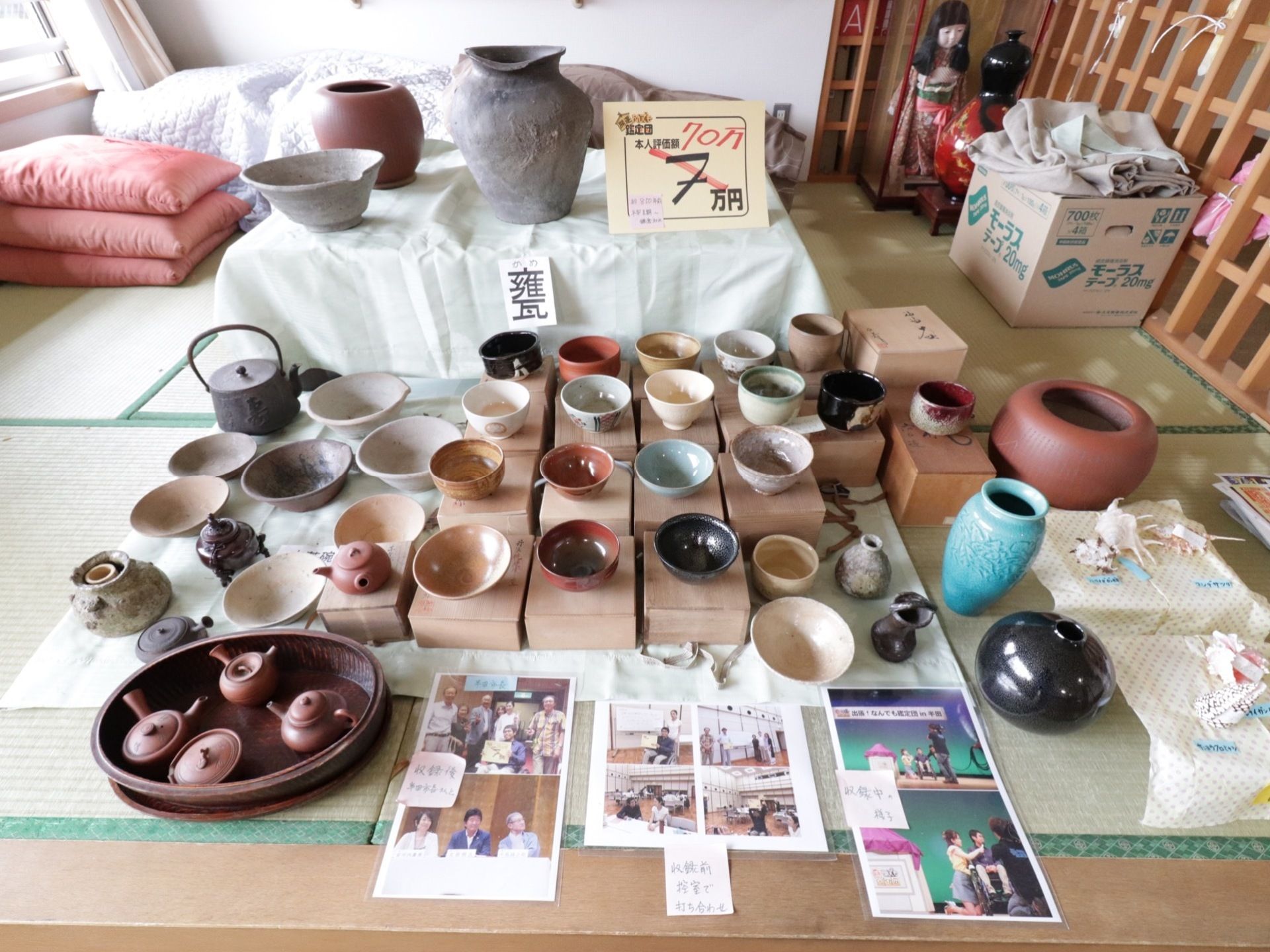 畳の敷かれた共有スペース。さまざまな茶碗や茶器、花瓶などが並べられている。日本人形が飾られている。窓からの光が入り明るい。