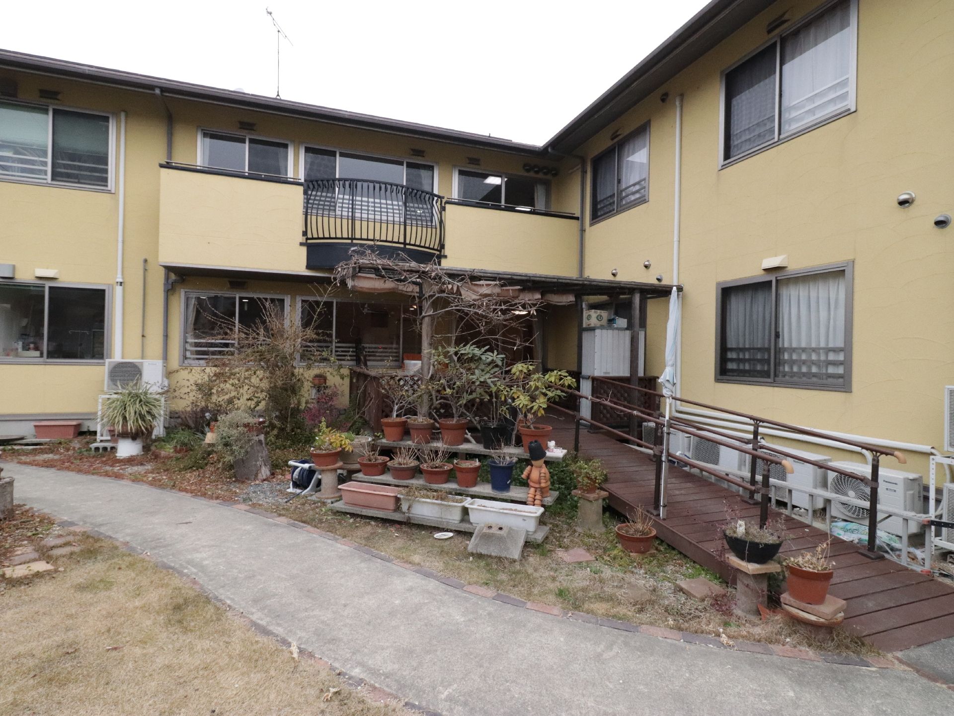 植木鉢や植栽があり、建物に続くスロープが取り付けられた中庭