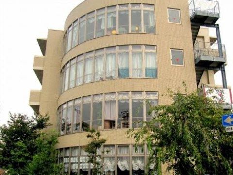丸いアーチを描いた大きな窓ガラスが印象的な施設外観。