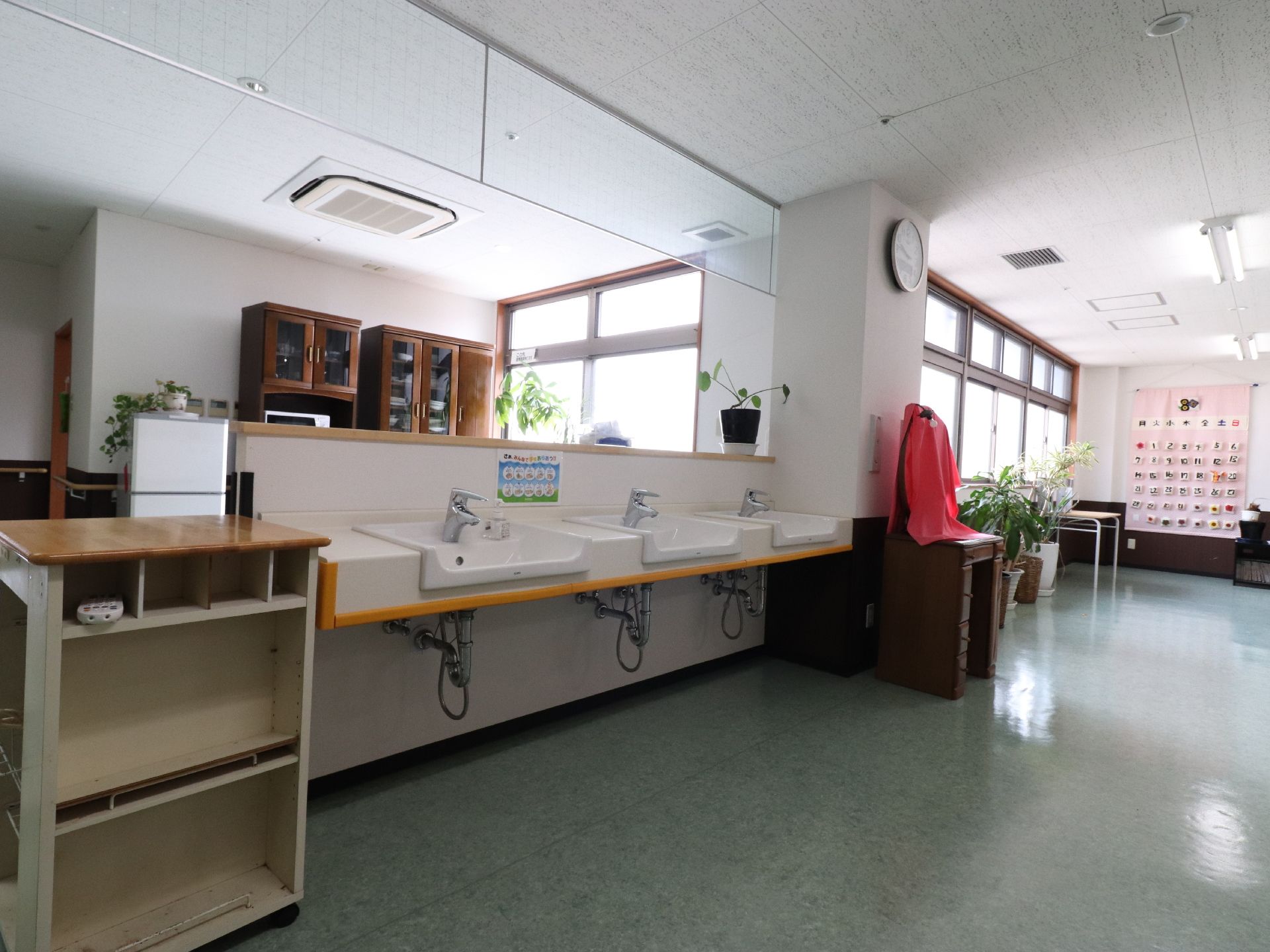 フラットなフロアに洗面台が3つ並んでいる。洗面ボウルの下にはそれぞれ車椅子が入ることのできる空間が設けられている。
