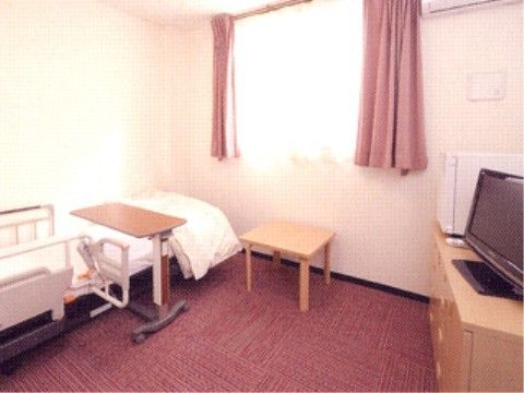 居室には赤い絨毯が敷いてある。ベッドには落下防止の柵があり、食事をするためのテーブルが設置してある。