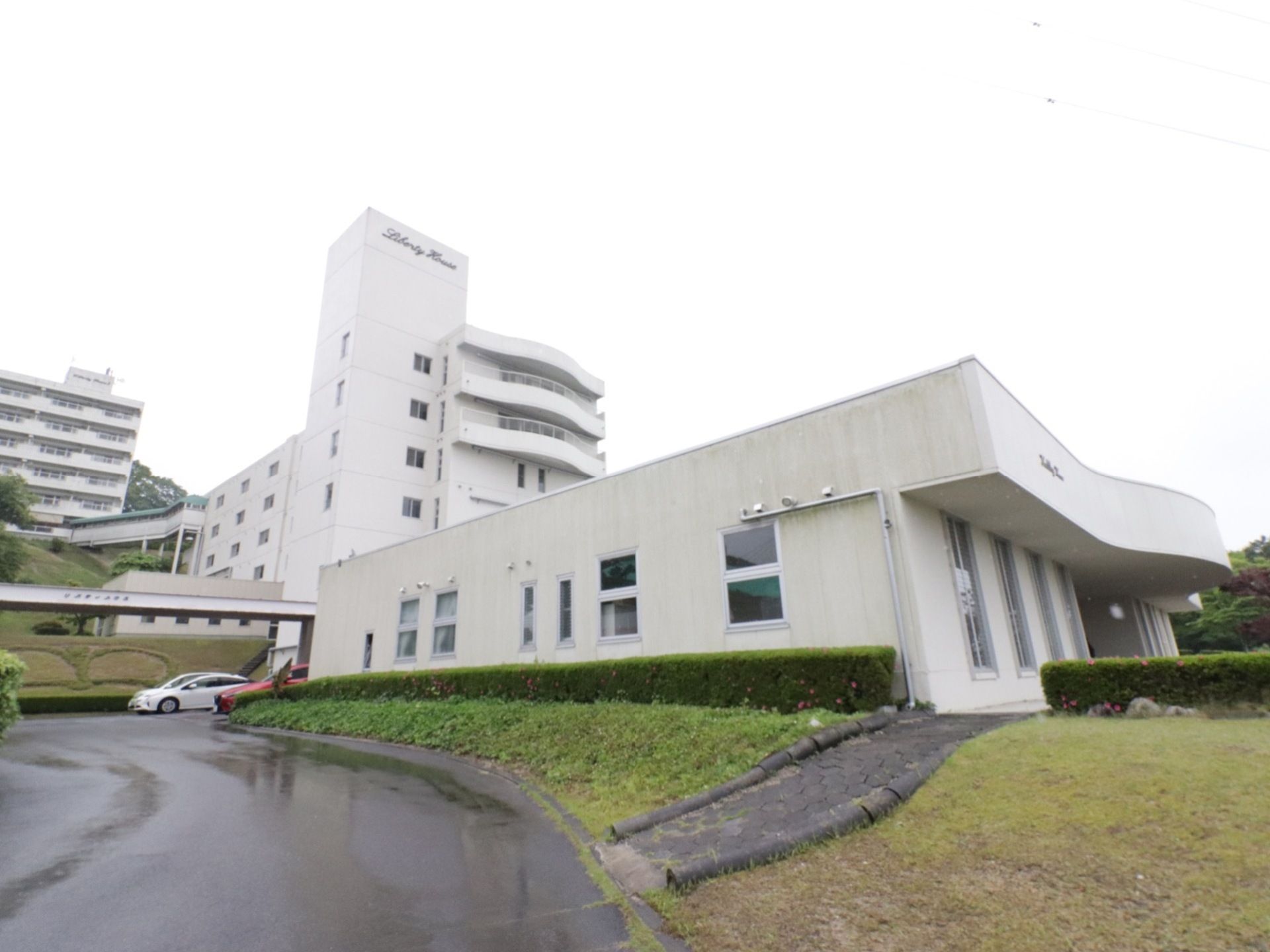 白い建物が、三棟並んでいるのが見える。手前の建物は、背が低く、一階建てであることが分かる。奥の二棟は、背の高い建物である。