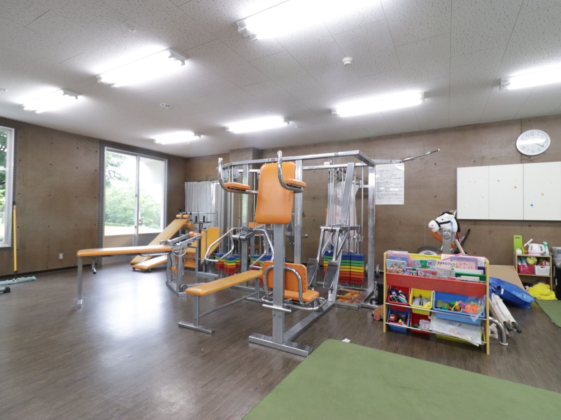 フローリングの床に、コンクリート壁の、広々としたスペースの部屋である。天井には、蛍光灯がたくさん設置されている。