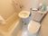 トイレと一体型のユニットバスである。中央の壁に洗面台を設置している。バスタブにはシャワーを備え、ビニールのカーテンで仕切るようになっている。