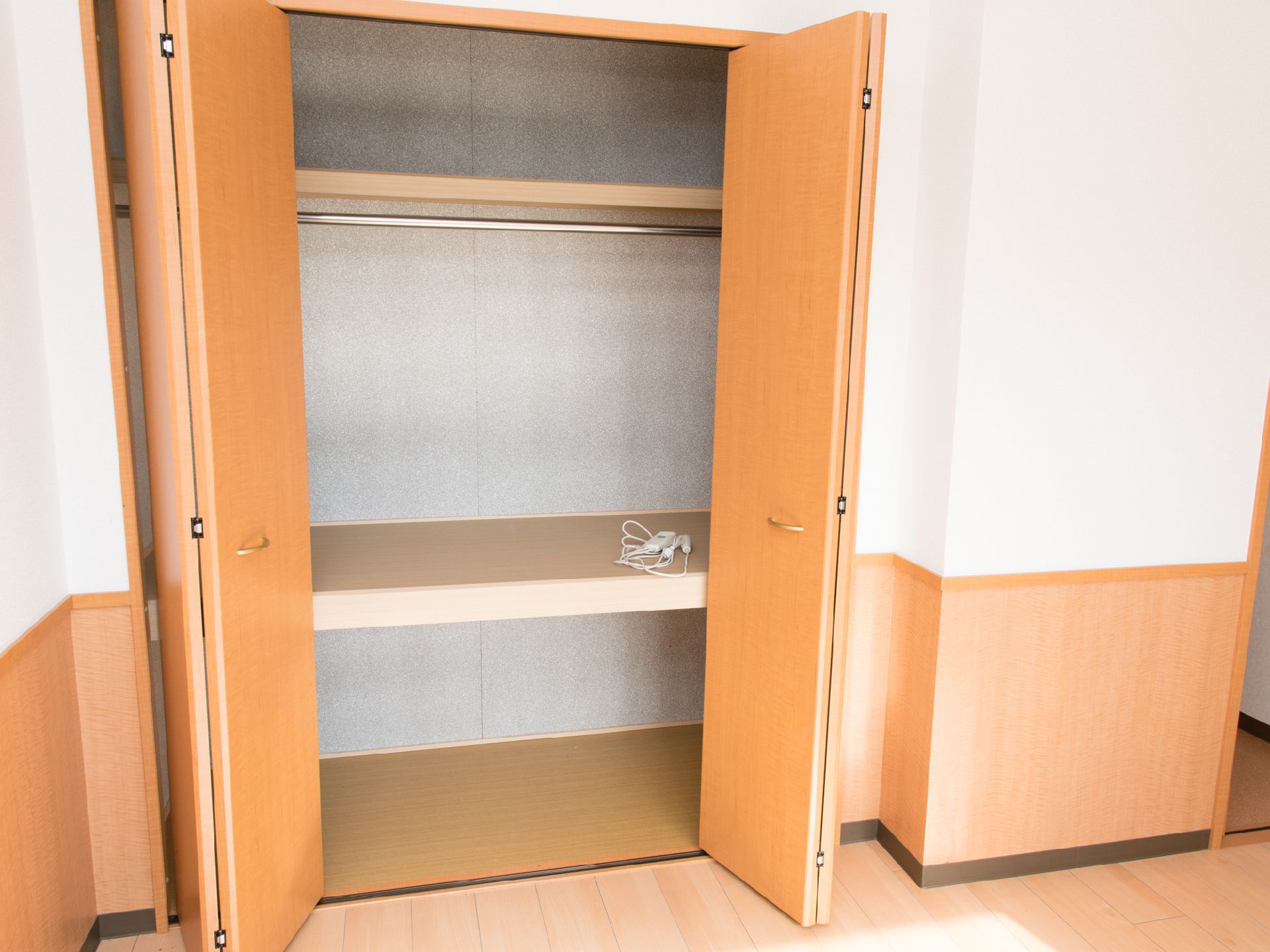 居室に備え付けの木目調の扉が部屋の雰囲気にマッチした収納スペース。衣類、小物など様々な物の収納に利用できる。
