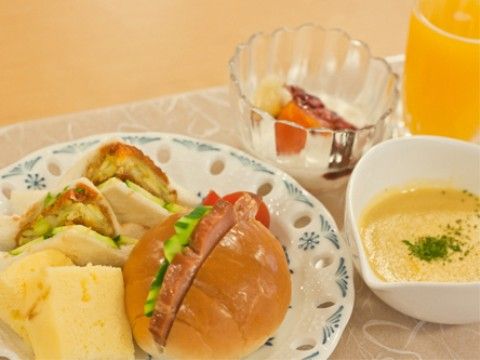 サンドイッチ、スープ、デザート、ジュースが載ったトレイ