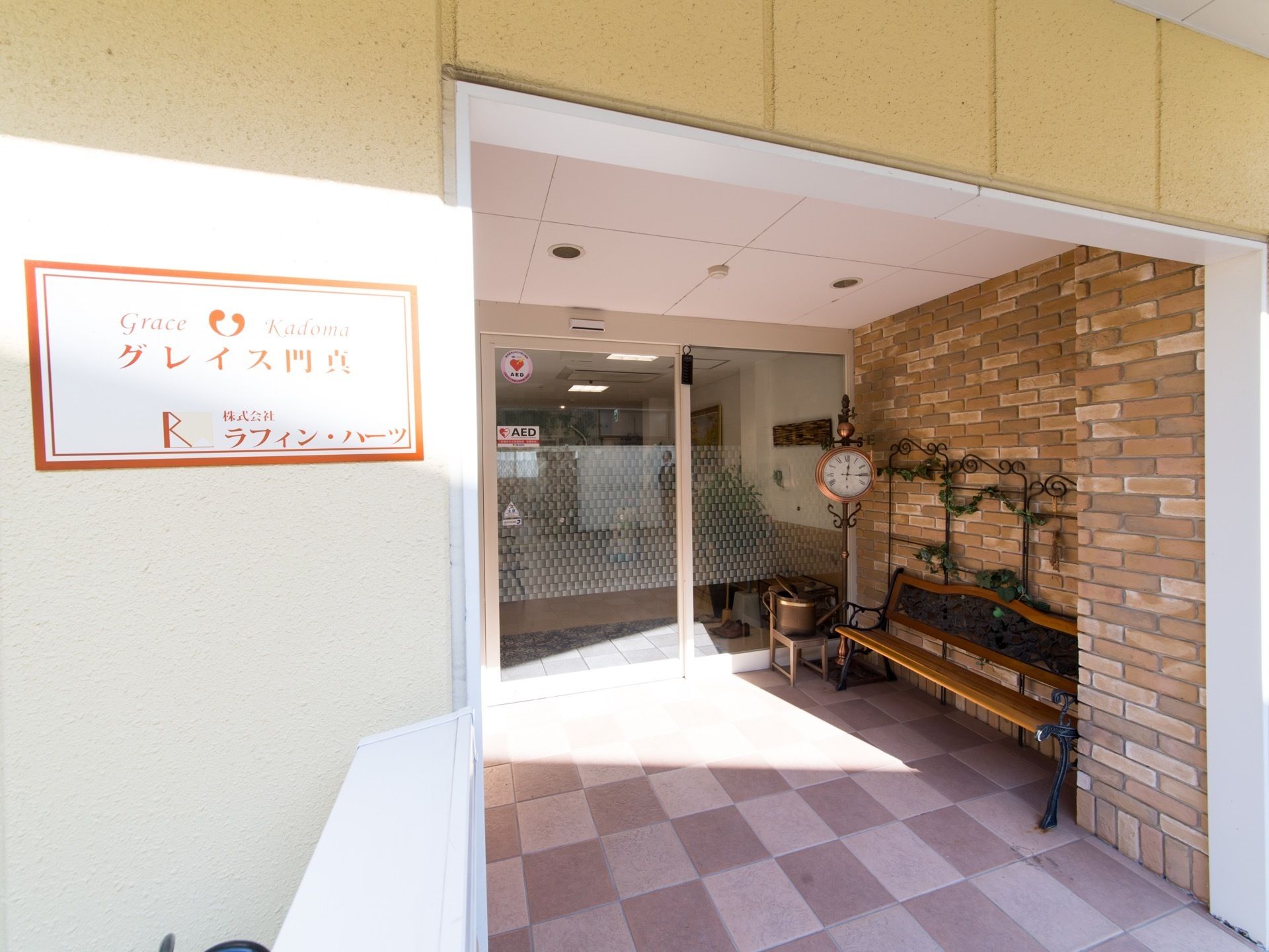 玄関の前には屋根付きのスペースが設けられている。時計やベンチが置かれ、おしゃれな雰囲気になっている。