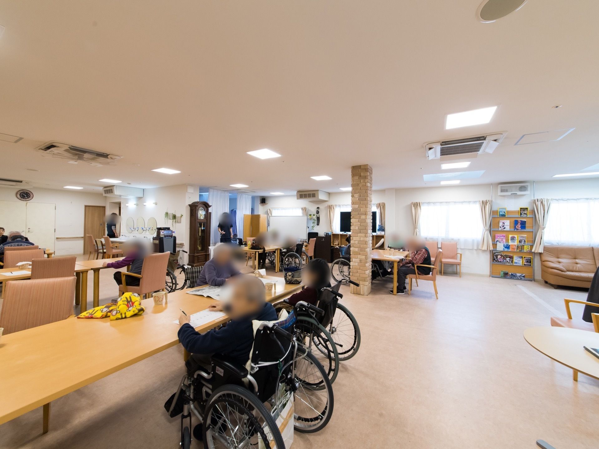 広々とした共有スペースに、ダイニングテーブルやソファが置かれている。入居者様が気軽に集い、寛いでいる。