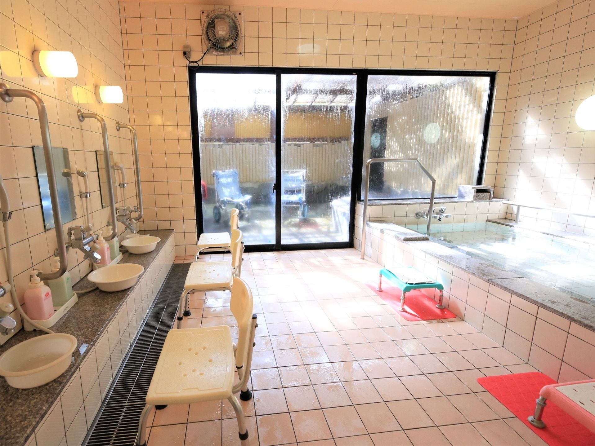 広い浴室の洗い場に椅子を設置しており、安全に座って体を洗うことができる。前の壁には手すりが取りつけられている。