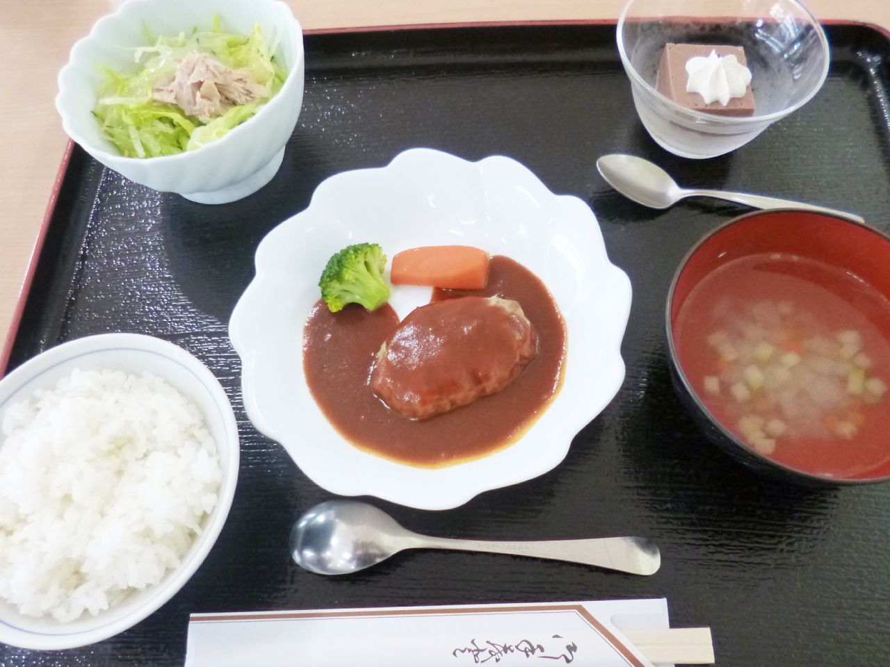 デミグラスハンバーグとツナとキャベツのサラダにデザートが付いたメニュー