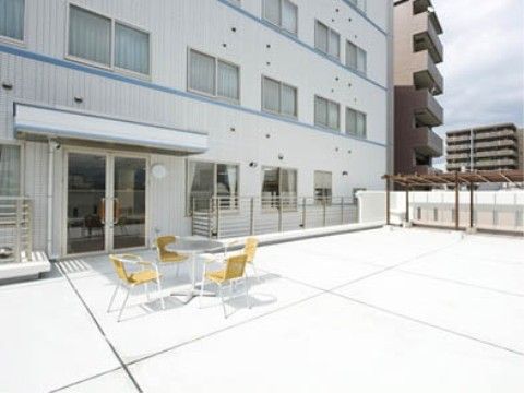 テーブルと椅子が置かれている、広く日当たりのよいテラス