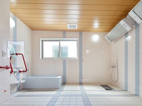 窓があり、浴室全体を温めるヒーターが備わっている浴室である。ピンク色を基調としているが、手すりが赤くとても目立っている。