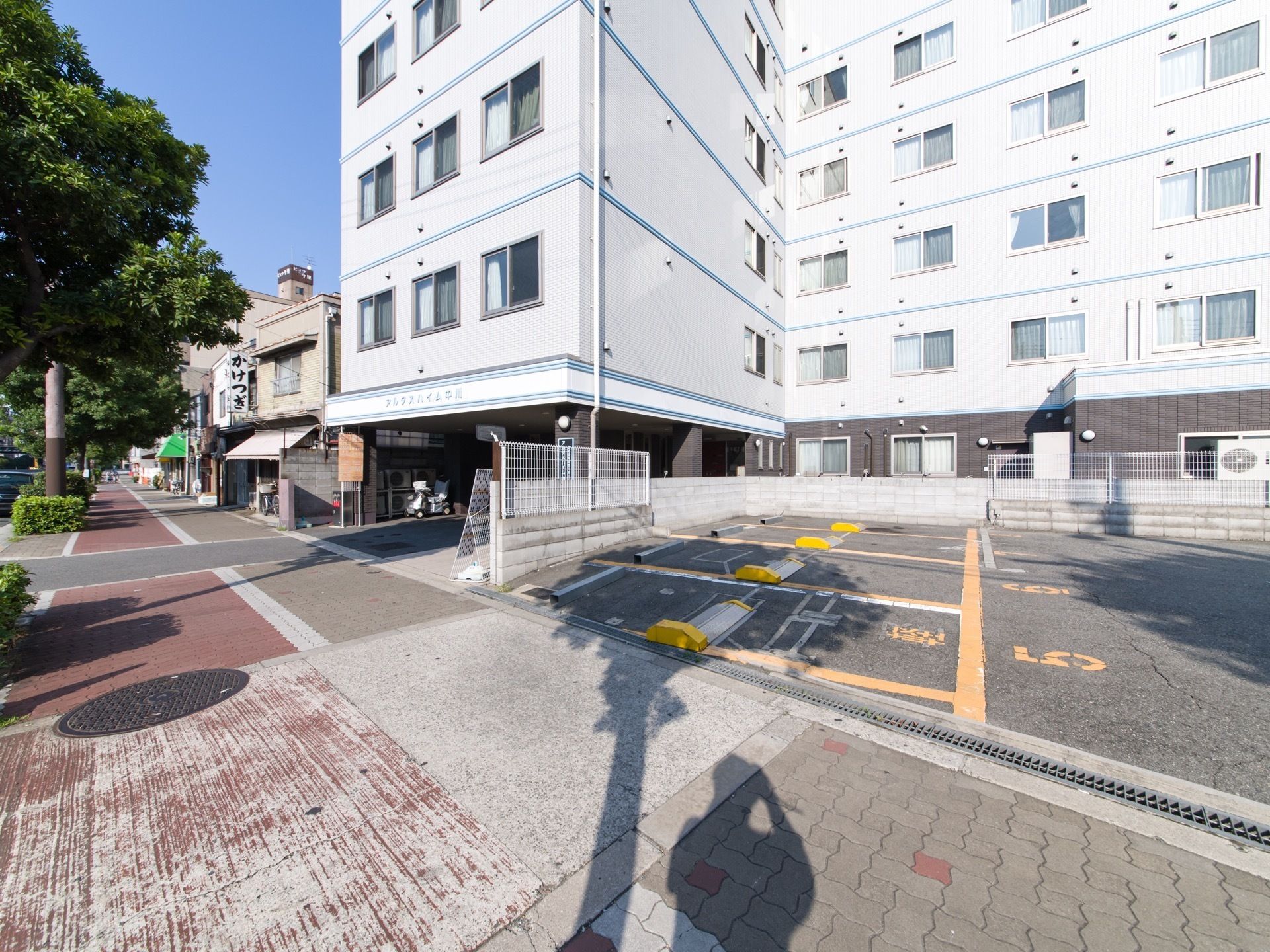 街路樹が植えてある歩道に面して立地している建物の１階部分には駐車スペースが設けられており、雨の日など便利である。
