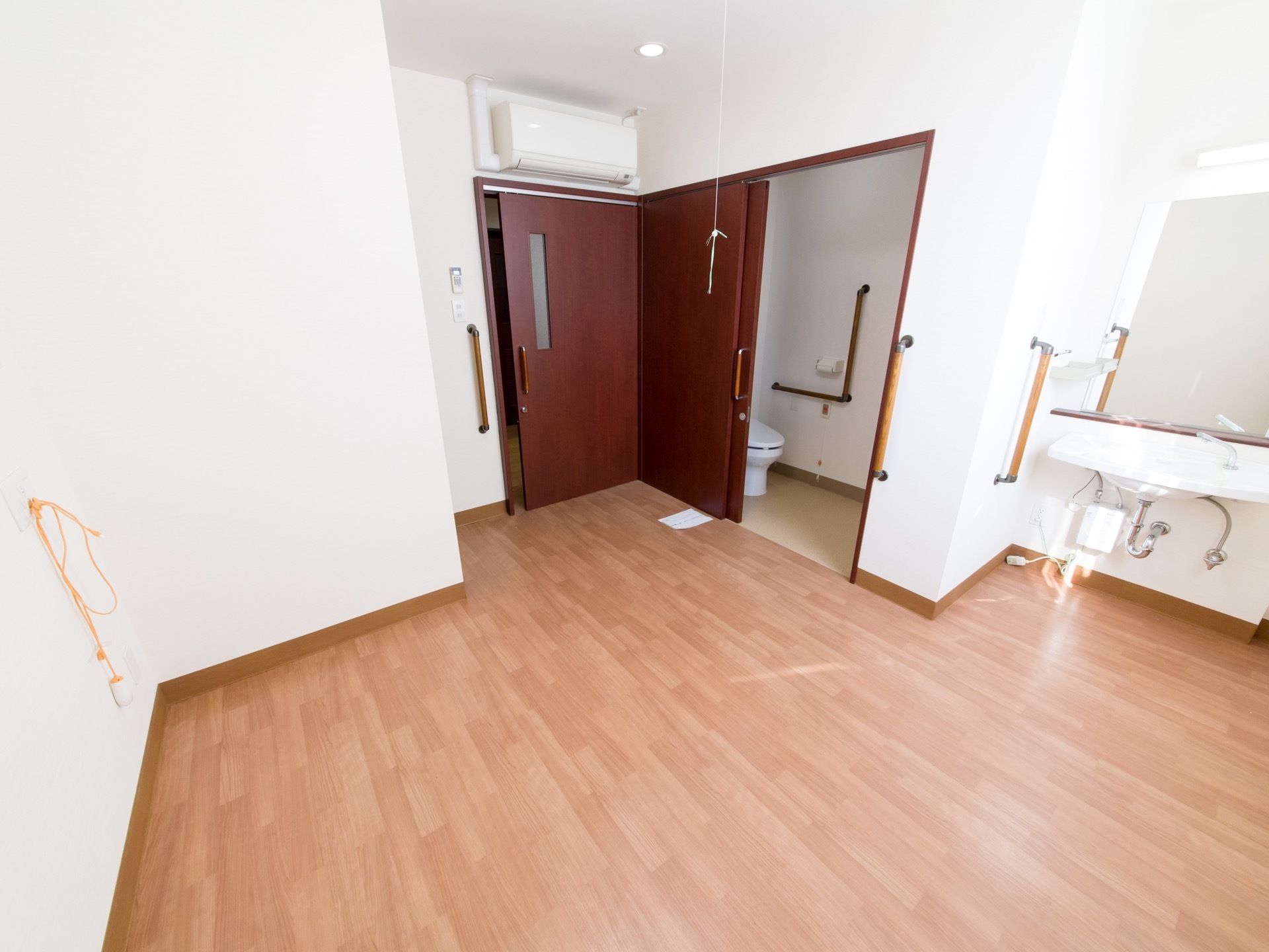 広々としたスペースがある居室内には洗面スペース、トイレが設けられている。入り口の扉とトイレの扉は幅が広いタイプが設置されている。