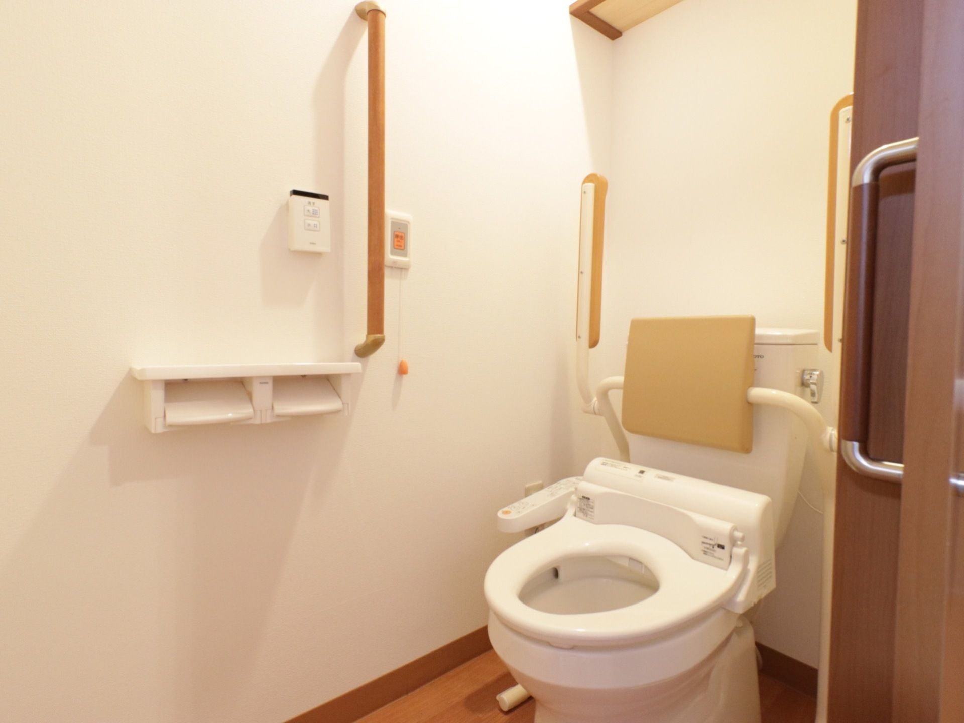 居室のトイレは安全面を配慮し、手すりやセーフティーバーが設置してある。躓き防止のため、備品は作り付けの棚に置くようになっている。