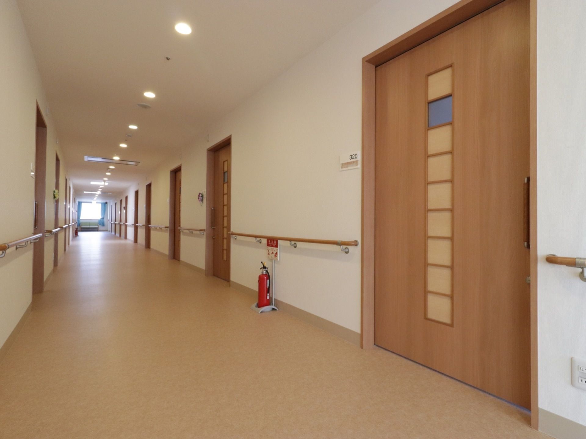 すりガラスの窓がついた居室のスライドドアである。壁には部屋番号と入居者様の名前が書かれたプレートが設置されている。