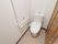 居室に備わっているトイレである。白を基調としており、清潔である。壁にはL字型の手すりや緊急呼び出しボタンが設置されている。
