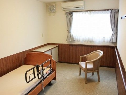 アイボリーとブラウンの色合いが落ち着いた雰囲気のお部屋である。ベッドの転倒防止バーや連続した手すりで安全に使用できる。